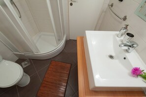A bathroom with a shower, toilet, and sink. - Apartments Ivan (Preko)