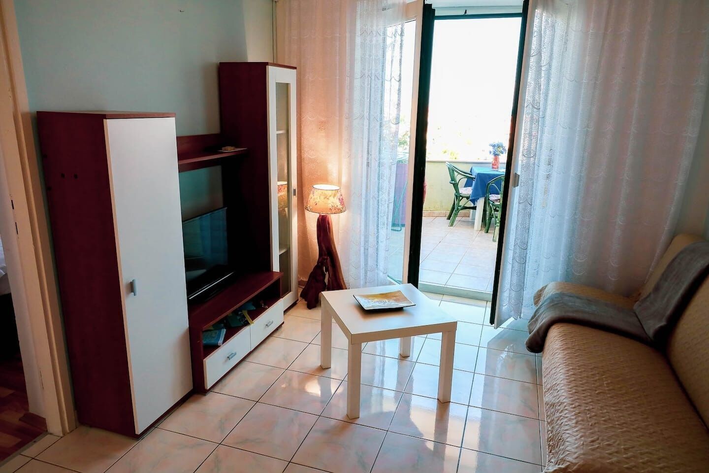 A compact living room with a TV, a small table, and a sofa.