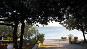 Caminho que leva a um portão com vista para o mar.