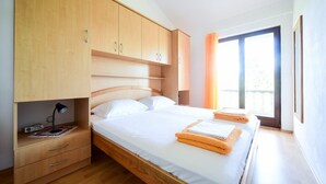 Une chambre à coucher avec un lit en bois, une table de chevet avec une lampe et une fenêtre avec des rideaux.