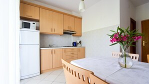 Une cuisine moderne avec des meubles en bois, un plan de travail blanc et un coin repas comprenant une table et des chaises.