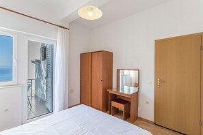 Egy hálószoba, amelyben található egy ágy, egy fa szekrény, egy tükörrel ellátott íróasztal, valamint egy erkély, ahonnan kilátás nyílik a tengerre.