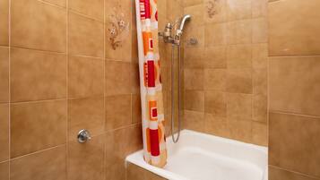 Un baño con ducha, bañera y retrete.
