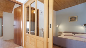 Una camera da letto con un letto, un comodino, una lampada e un quadro appeso al muro.