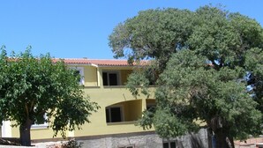 A two-story building with a yellow facade and red-tiled roof. There are two visible windows on the upper floor and one on the ground floor. - Apartment Zana (Sali)