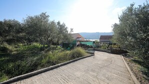 Un sendero que lleva a una casa con vista a un cuerpo de agua y montañas a lo lejos.