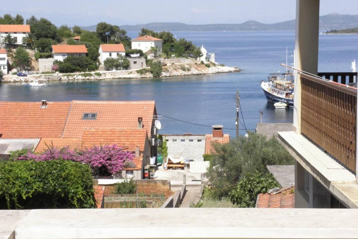 A coastal town with buildings, a bridge, and boats on the water.