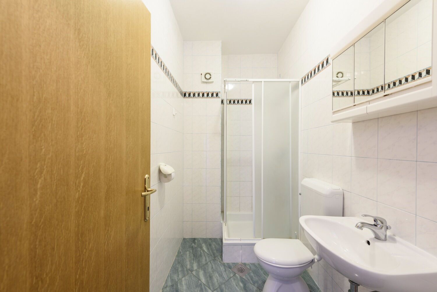 Une salle de bain équipée de toilettes, d’un lavabo et d’une douche.