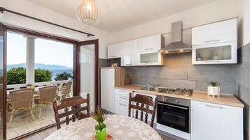Apartamento (A2) | Cozinha privada | Geladeira, cooktop, talheres/pratos/utensílios de cozinha