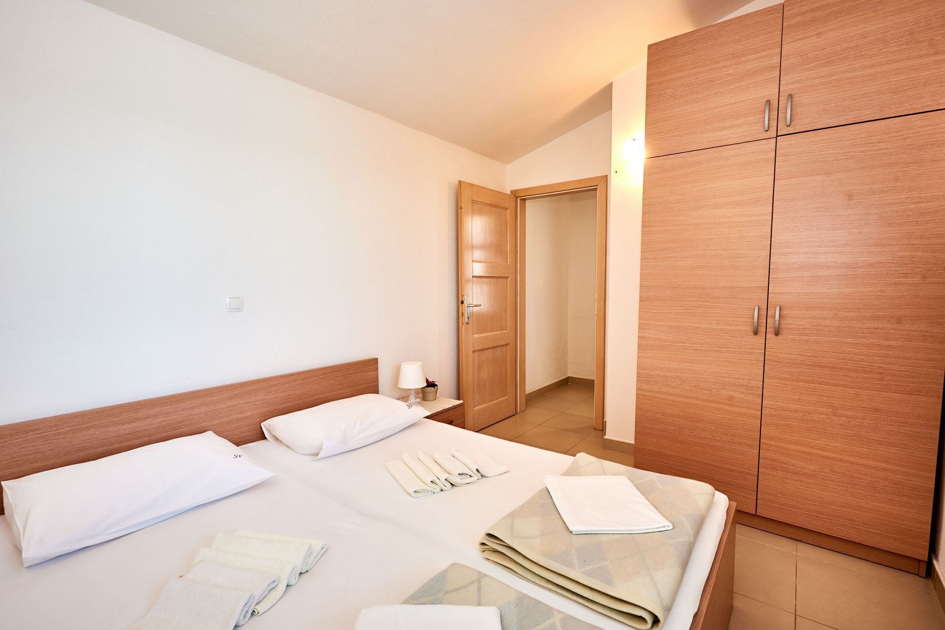 A hotel room with a bed, a nightstand, and a wardrobe.