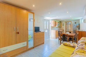 A compact living space with a kitchenette, a dining area, and a bed. - Apartment Mici 1 (Cres)