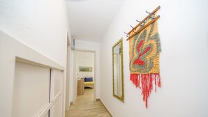 A hallway with a wooden floor, white walls, and a door at the end. - Apartment Nedjeljka (Postira)