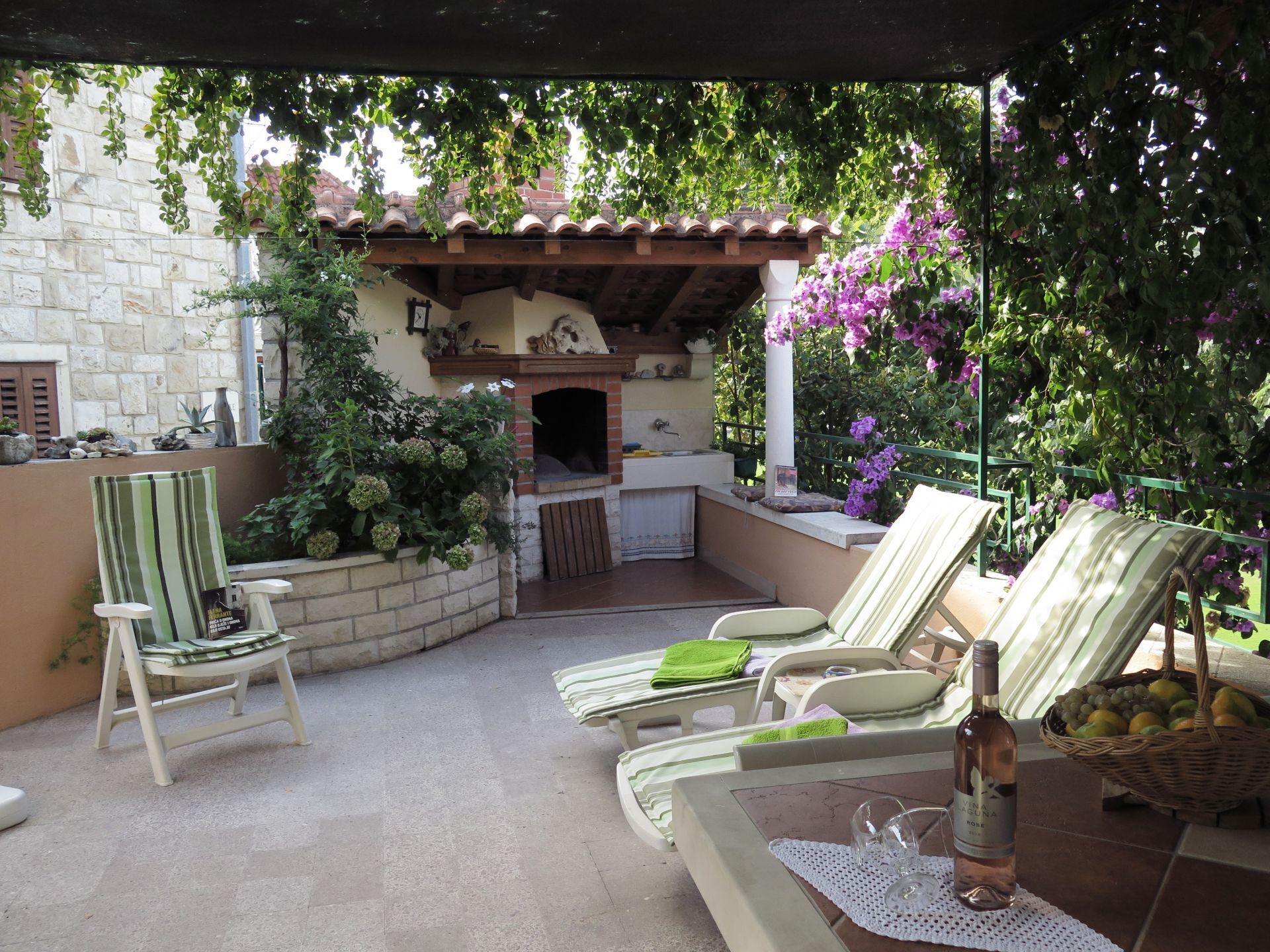 A patio with outdoor seating, a barbecue area, and a stone wall.