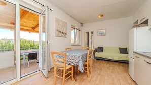 Un espacio habitable compacto con una mesa de comedor, sillas, un sofá y una kitchenette.