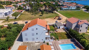 Una zona residencial con piscina, un edificio grande y vista al mar.