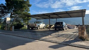 A parking area with a covered shelter, a Toyota truck, and a blue car. - Apartment Jasna (Jelsa)