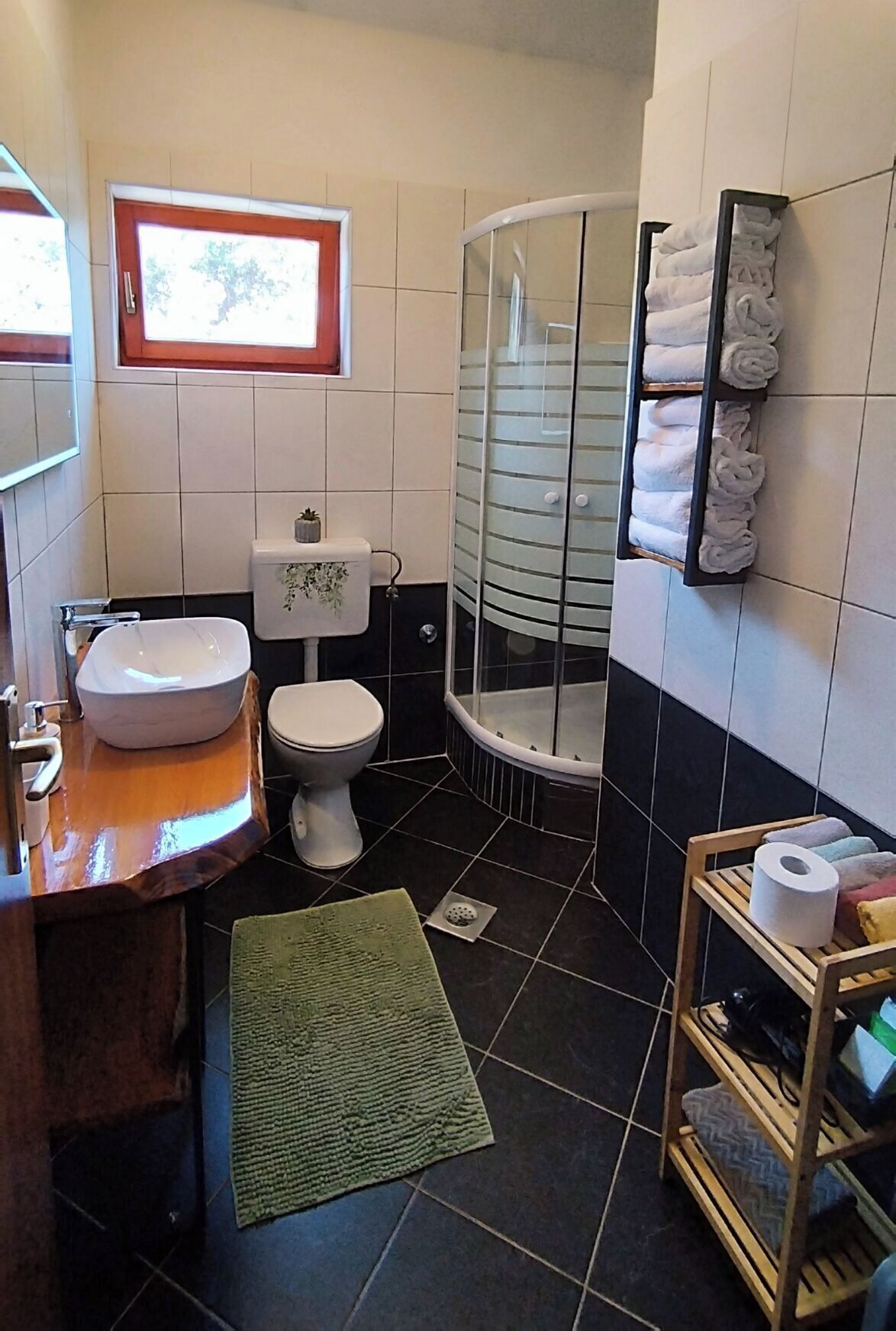 A bathroom with a white sink, toilet, and glass shower enclosure.