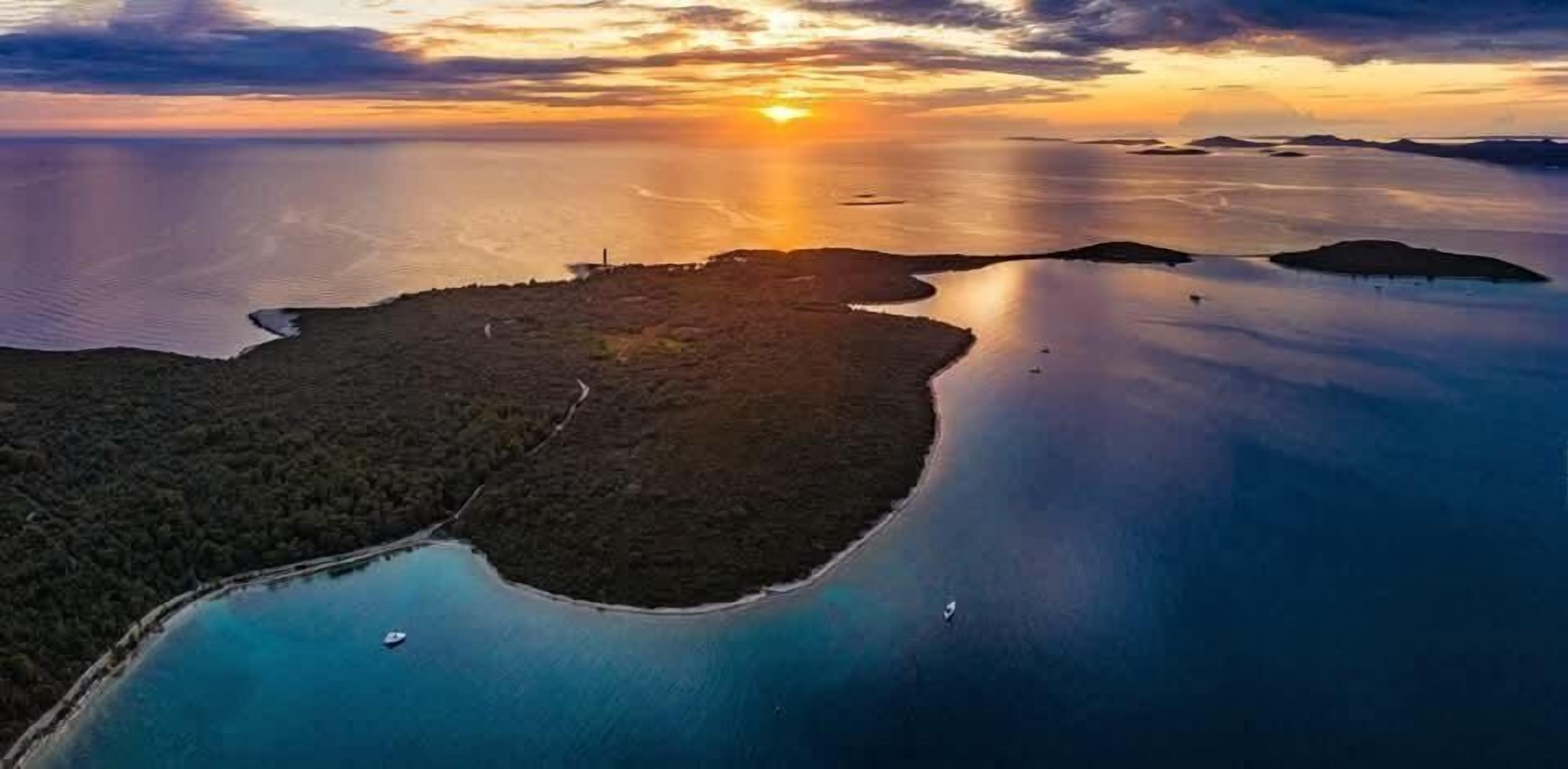 An aerial view of a coastal area with a small island surrounded by calm waters.