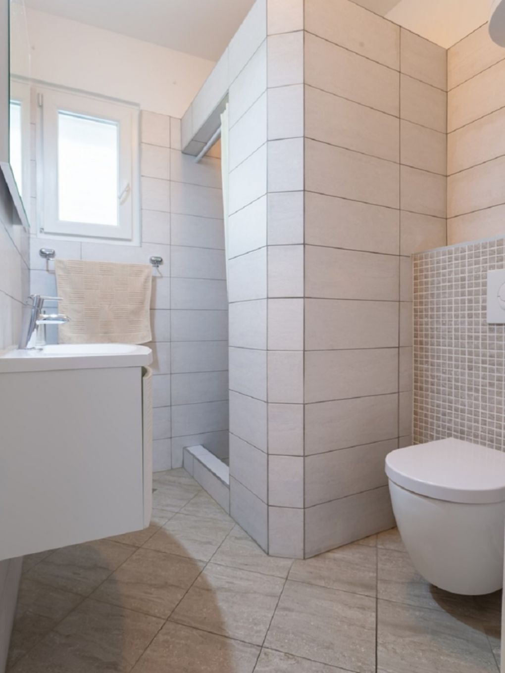 A modern bathroom with a toilet, sink, and shower area.