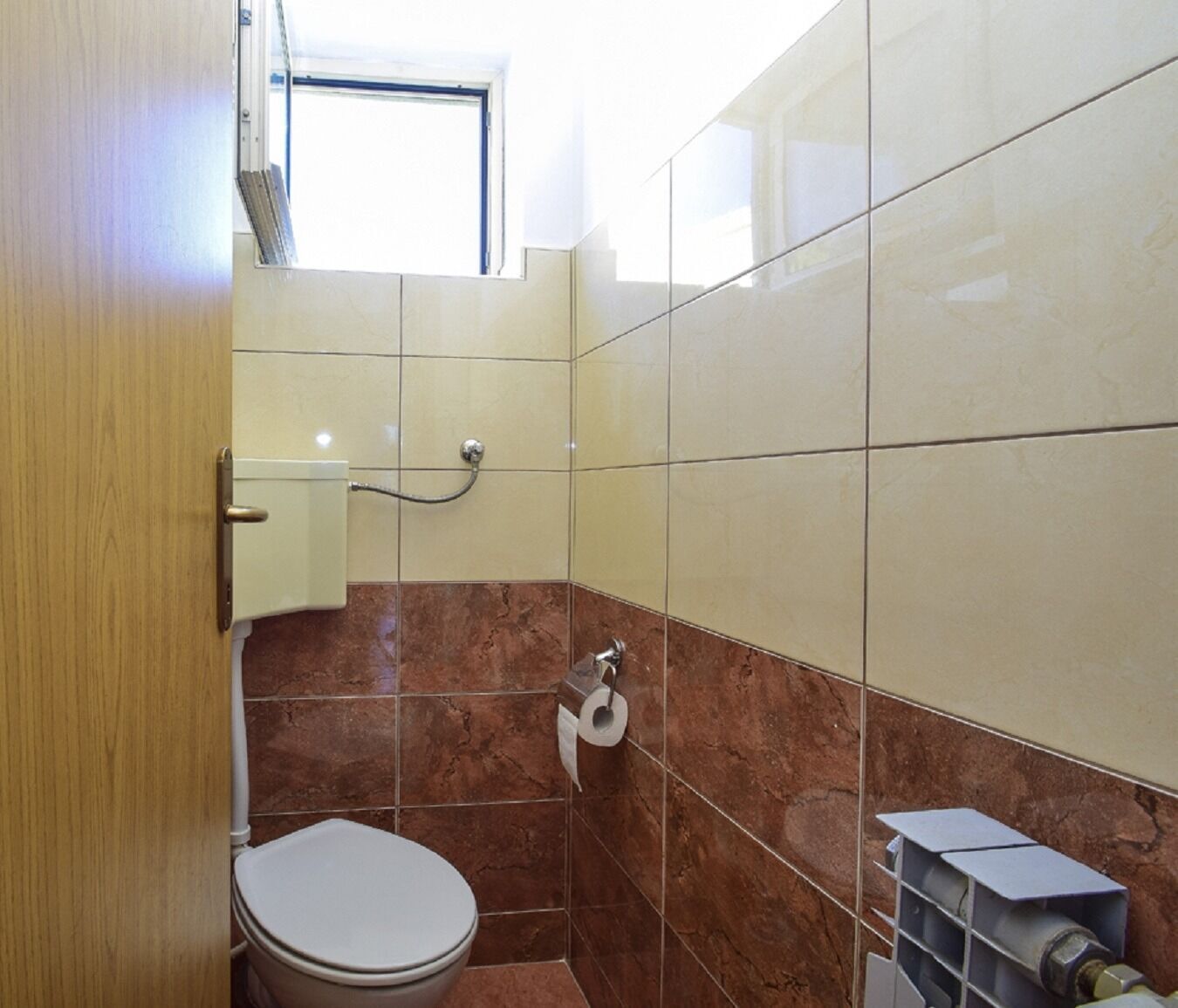 Ein Badezimmer mit Toilette, Dusche und Fenster.