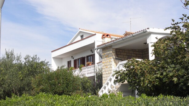 Un edificio blanco con un balcón y una chimenea.