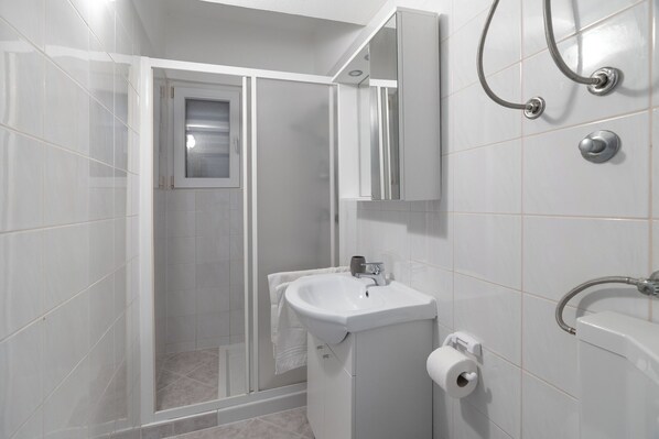 Une salle de bain moderne équipée d’une douche, de toilettes et d’un lavabo.