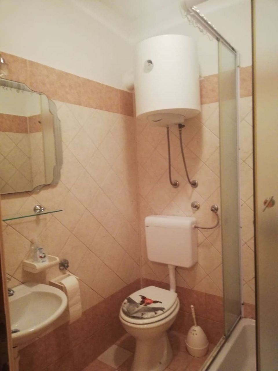 A small bathroom with a toilet, bidet, and a glass shower enclosure.