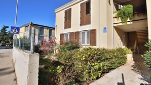 A two-story building with a balcony, a pedestrian crossing sign, and a parking sign. - Apartment Nadica (Fazana)