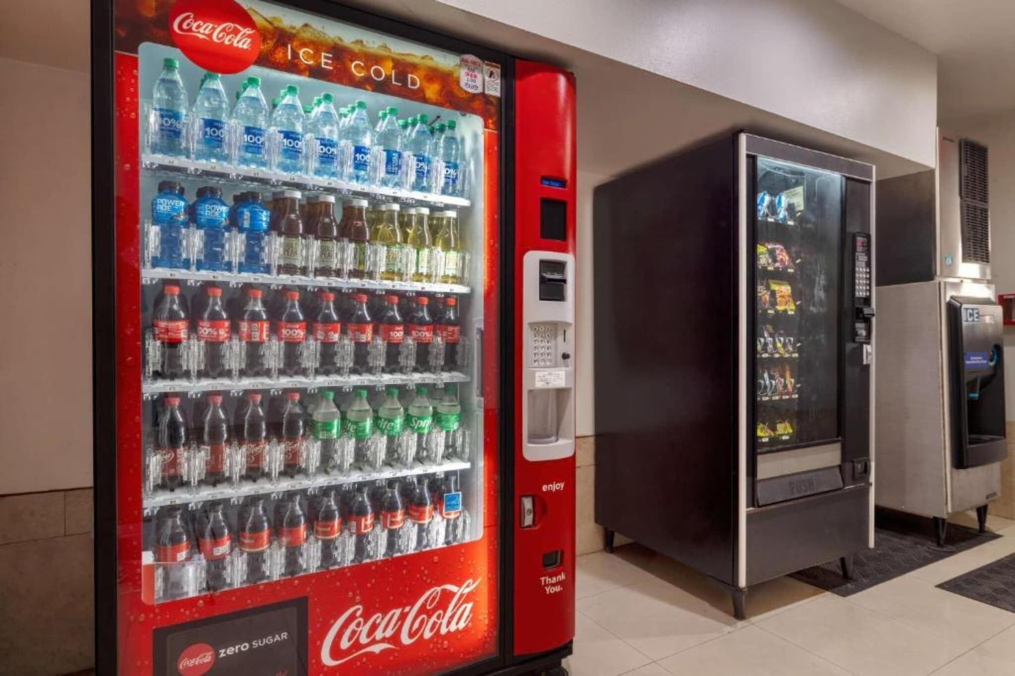 A Coca-Cola vending machine with a variety of beverages and a digital display.