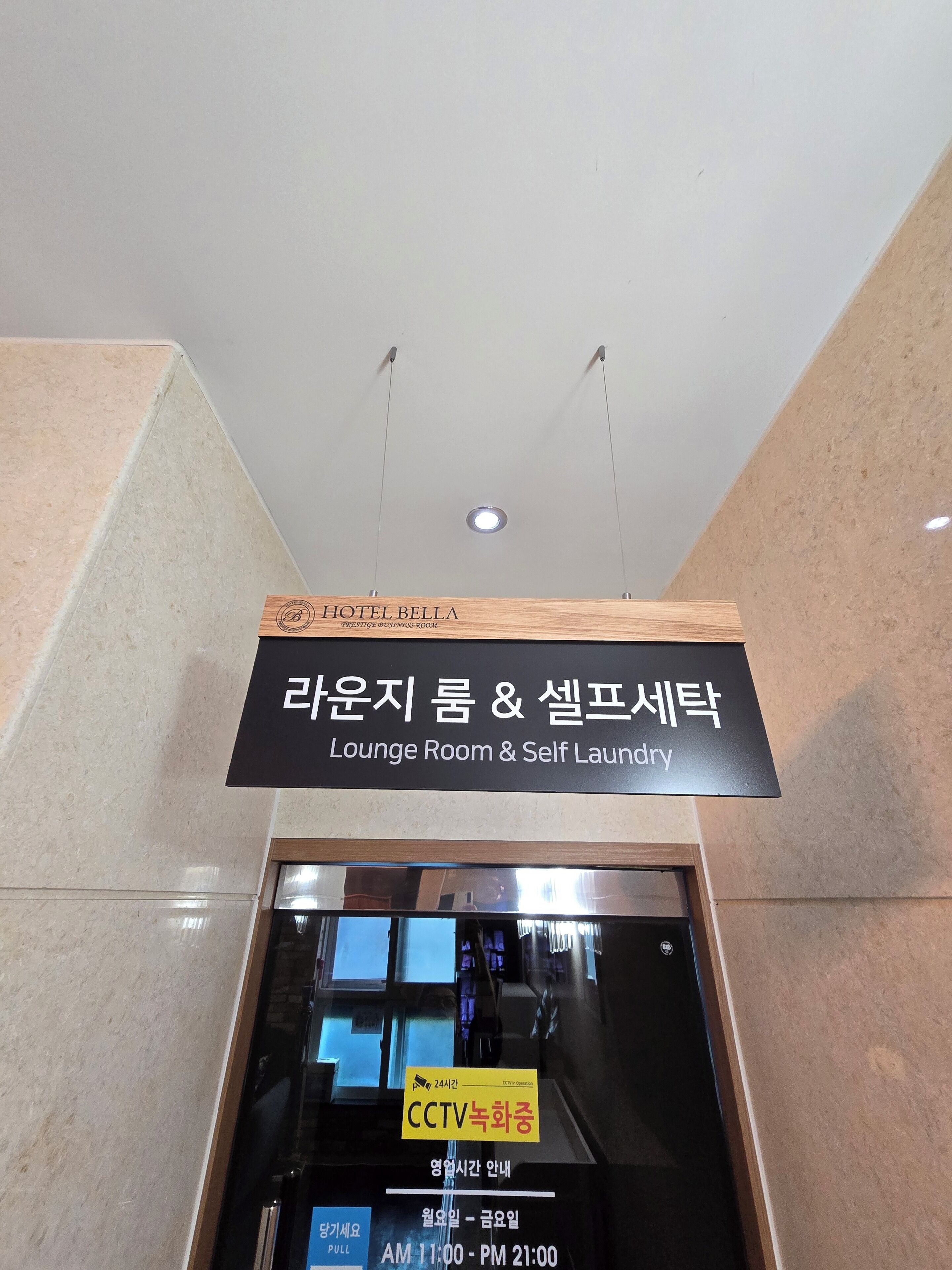 A hotel sign indicating a lounge room and self laundry service.