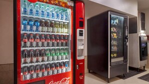 A Coca-Cola vending machine with a variety of beverages, including water and sodas, in a commercial setting. - Cozy Queen Bed|Pool|Free Parking (McAllen)