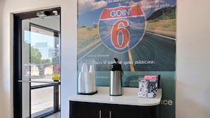 Zona de recepción con un cartel de un letrero de carretera que dice 'Goin' 6' y un mostrador con una botella de agua y bolígrafos.