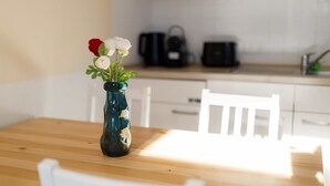 A wooden table with a vase of flowers in the center. - FullHouse Apartments AB5 Medium (Halle (Saale))