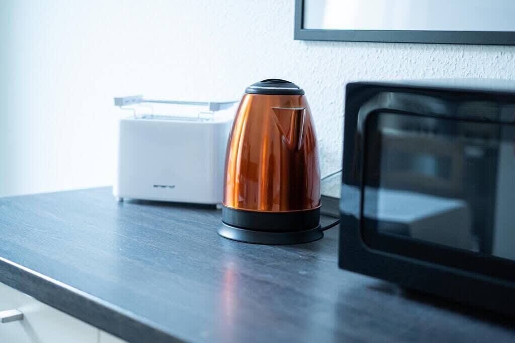 Uma bancada de cozinha com cafeteira e micro-ondas.