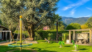 Un parque infantil con columpios, una estructura para escalar y un tobogán.