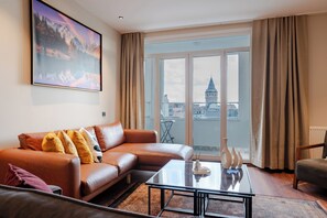 A modern living room with a leather sofa, a glass coffee table, and a large window offering a city view. - The Best in Beyoglu–Galata Tower View – Elevator – Renovated Interior – Balcony (İstanbul)