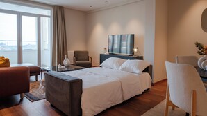 A modern hotel room with a large bed, a sofa, a chair, a desk, and a TV. - The Best in Beyoglu–Galata Tower View – Elevator – Renovated Interior – Balcony (İstanbul)