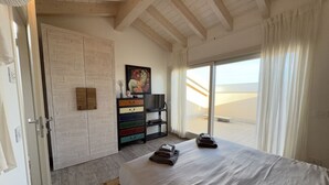 A bedroom with a large bed, a sliding glass door to a balcony, a wardrobe, and a painting on the wall. - 10 Min Walk from the Beach, Free Swimming Pool (Peschiera del Garda)