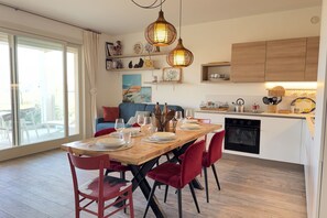 Una cucina moderna con mobili in legno, un tavolo da pranzo per quattro persone e un'ampia finestra.