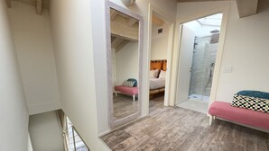 A room with a staircase, a bed with a headboard, a bench, and a shower area. - 10 Min Walk from the Beach, Free Swimming Pool (Peschiera del Garda)