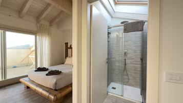 Una camera da letto con un letto, cabina doccia in vetro e vista sull'esterno.