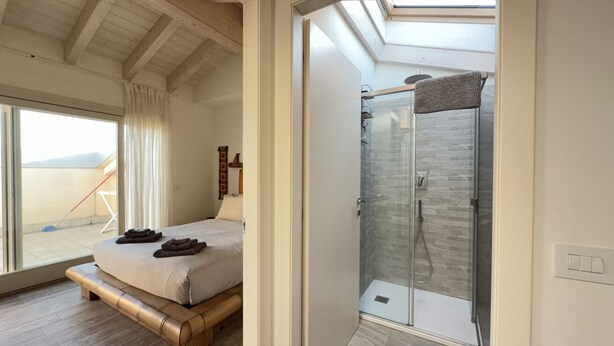 A bedroom with a bed, a glass shower enclosure, and a view of the outdoors. - 10 Min Walk from the Beach, Free Swimming Pool (Peschiera del Garda)