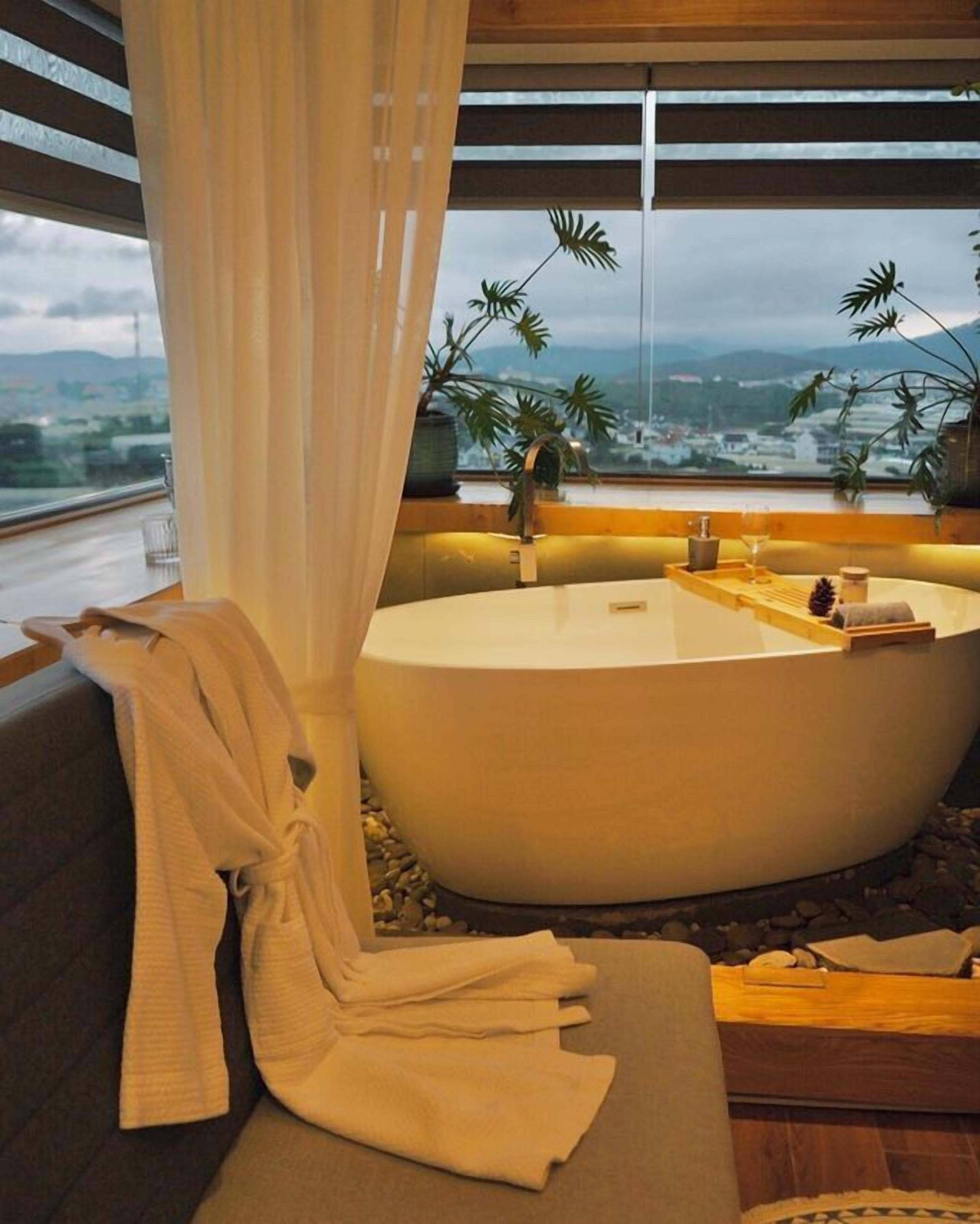 Ein modernes Badezimmer mit Badewanne, Handtuch und Blick auf die Stadt.