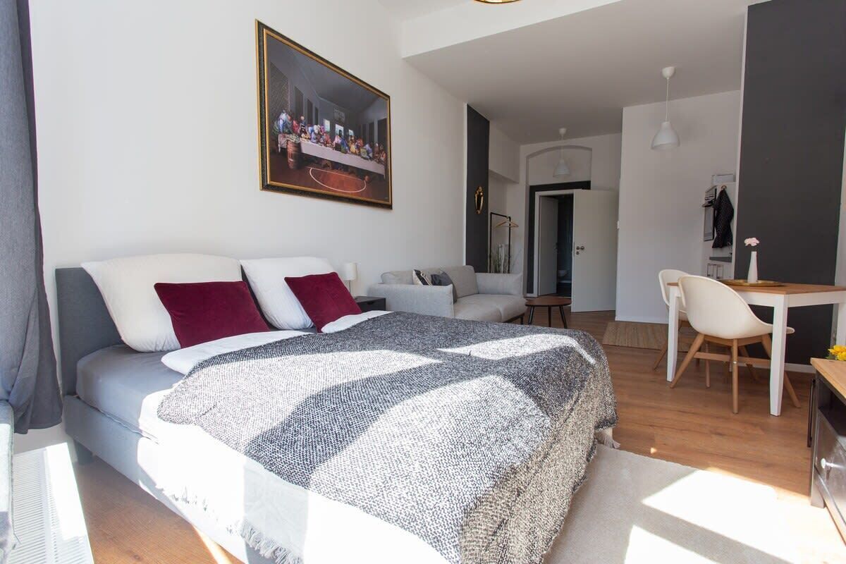 Een moderne slaapkamer met een groot bed, een bureau en een stoel.