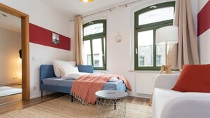 Une chambre à coucher moderne avec un lit, une petite table ronde et un canapé.