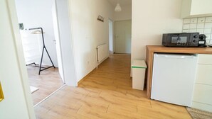 A kitchen with a microwave, a small refrigerator, and a wooden countertop. - FullHouse | Magdeburg | A9-4 | PrimeApartment (Magdeburg)
