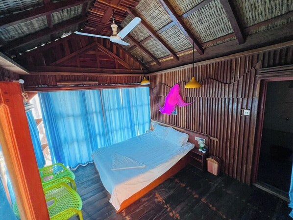 A room with a bed, a ceiling fan, a window with curtains, and a wooden wall. - Ocean Breeze Eco Resort Saint Martin (Saint Martin's Island)