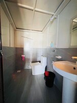 Een badkamer met toilet, wastafel en spiegel.