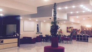 A spacious lobby with a reception desk, seating area, and a decorative plant centerpiece. - Ambiance Hotel Baku (Baku)