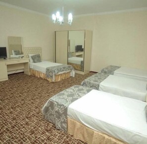 A hotel room with a bed, a desk, a chair, a wardrobe, and a mirror. - Ambiance Hotel Baku (Baku)